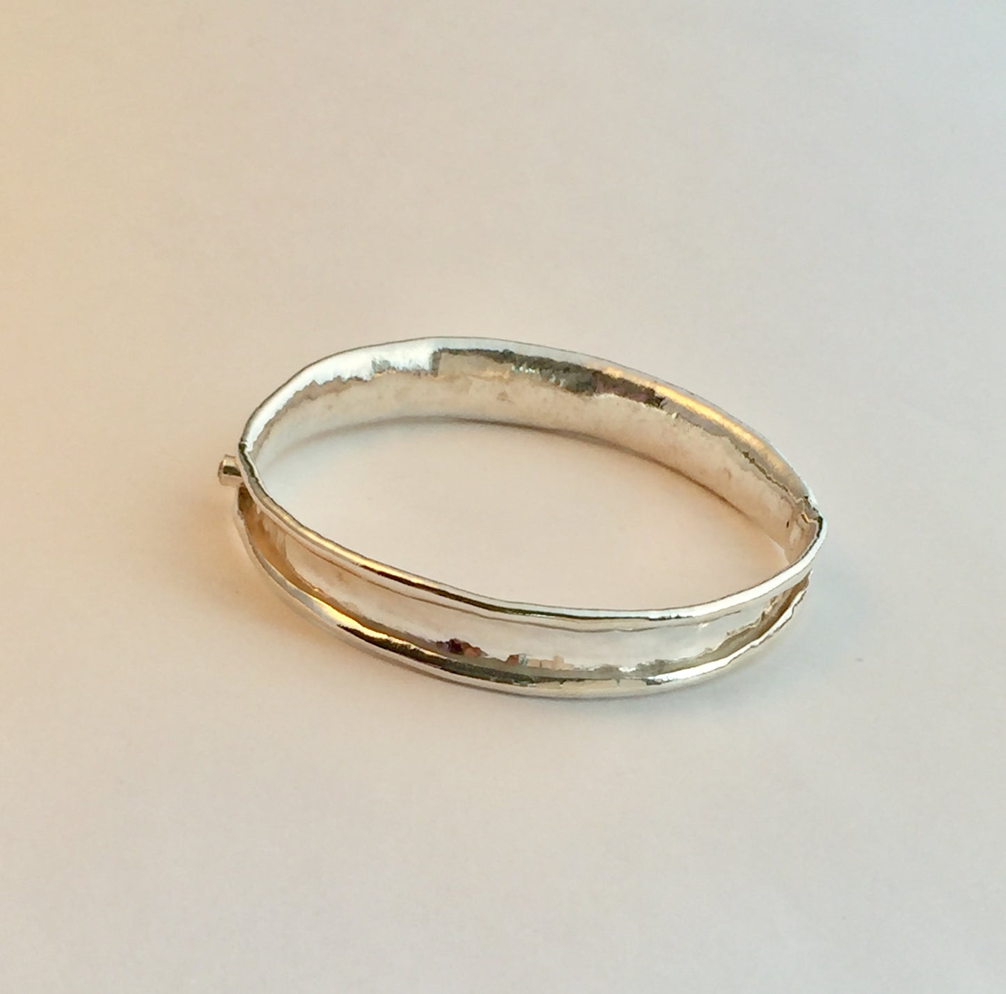 Sterling silver anticlastic bangle with white sapphire