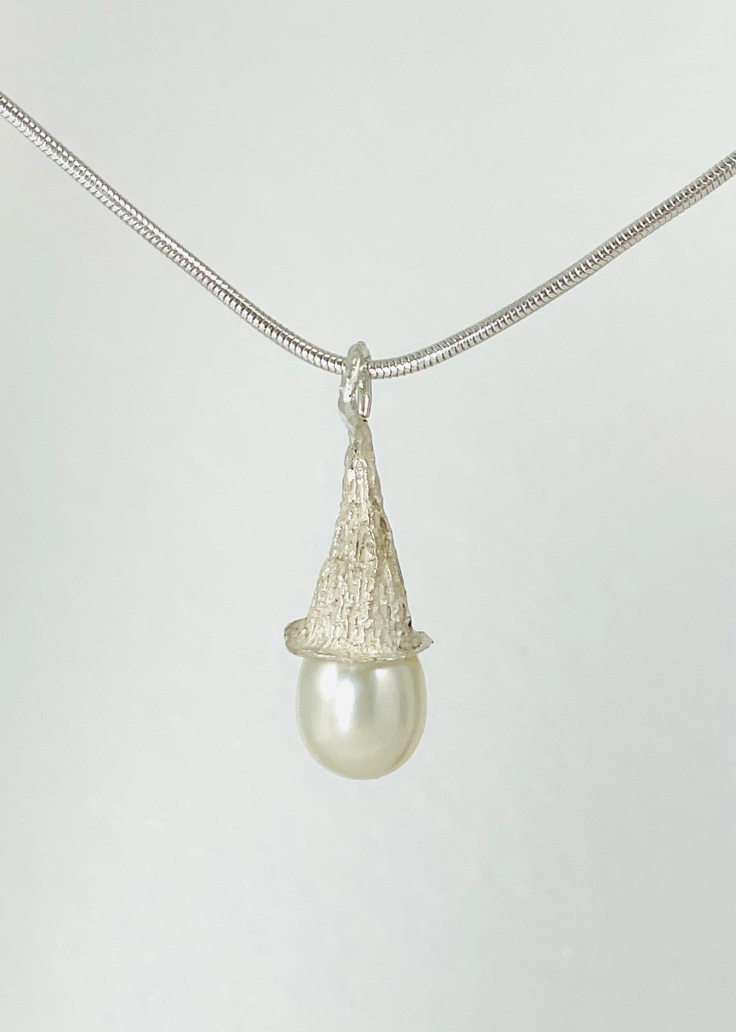 Fresh water tear drop pearl in a sterling silver textured cap.