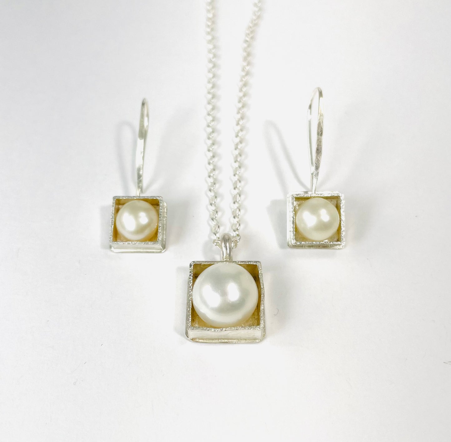 Sterling silver 'pearl in a box' pendant on an 18-inch curb chain.