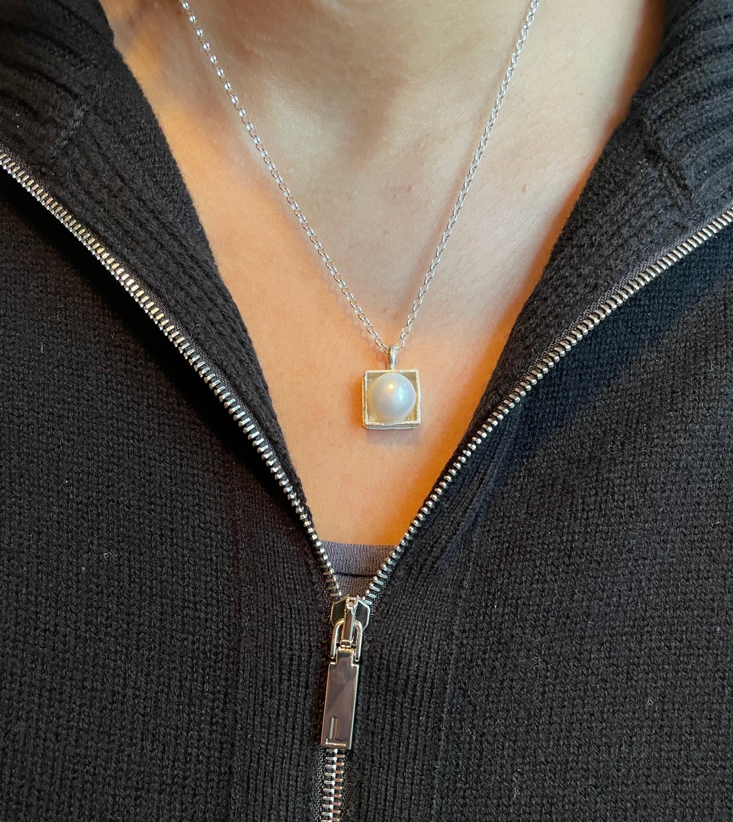 Sterling silver 'pearl in a box' pendant on an 18-inch curb chain.