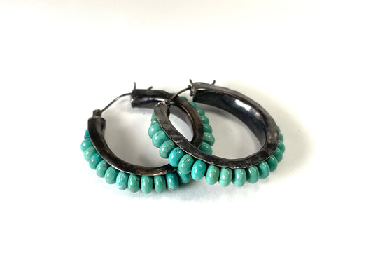 Oxidized sterling silver anticlastic hoop earrings with turquoise.