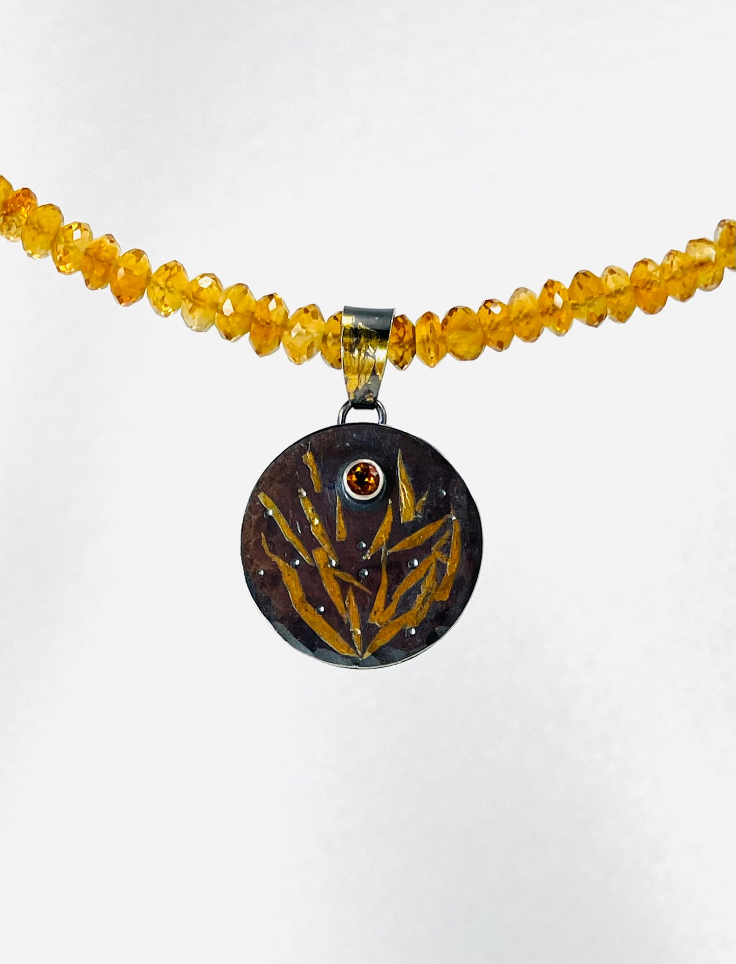Faceted citrine bead necklace with a sterling silver/gold pendant