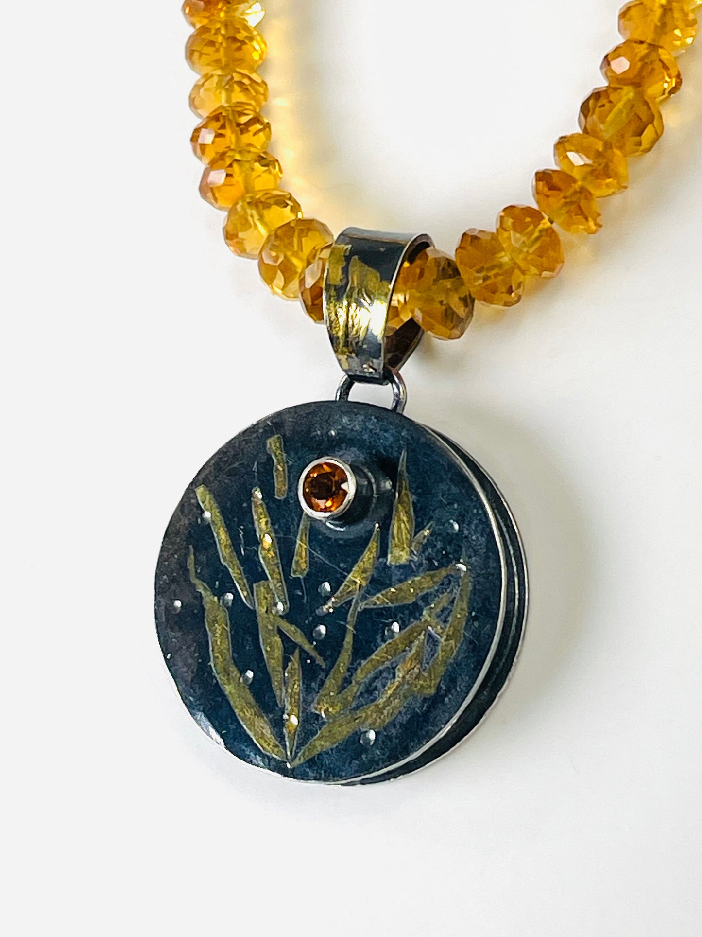 Faceted citrine bead necklace with a sterling silver/gold pendant