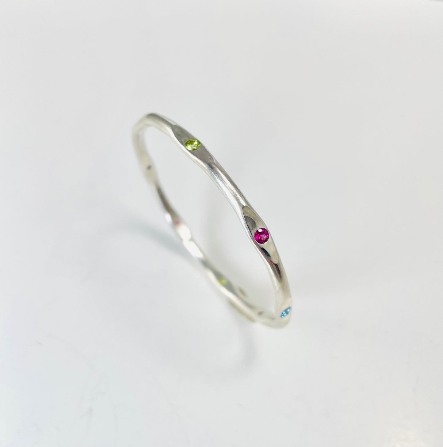 Sterling silver hand forged faceted bangle with 3mm gemstones.