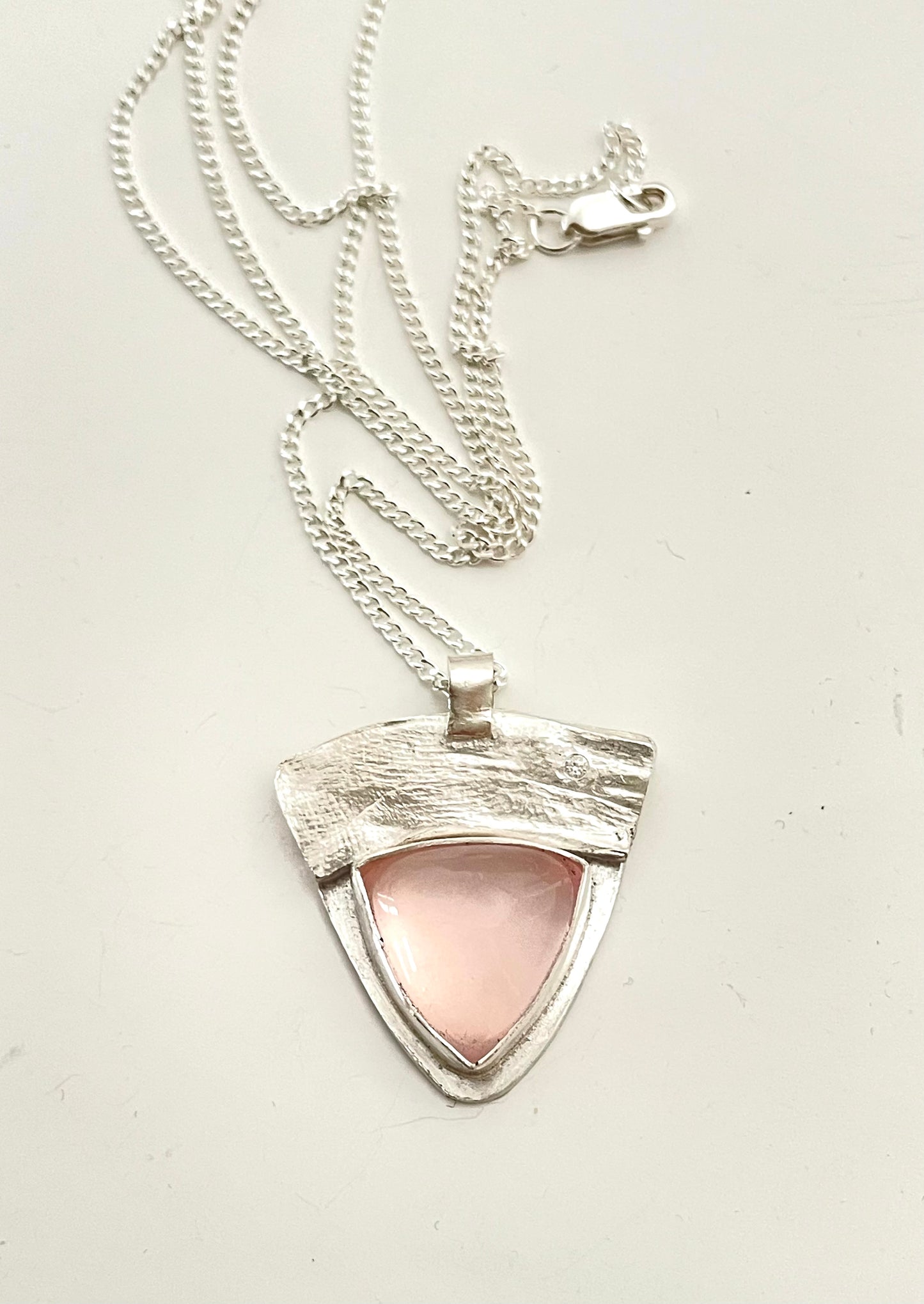 Sterling silver rose quartz pendant on a silver chain.